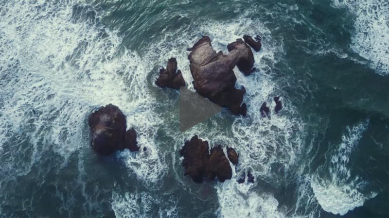 Aerial view of splashing waves on rocks